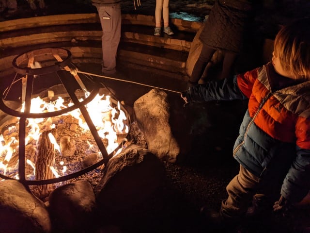 Roasting Marshmallows at Suncadia resort, Cle Elum, WA. A child wearing a jacket is holding a stick over a fire pit 